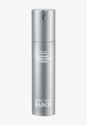 Flacon pompe argenté étiqueté "Crème éclatante 10 % THD (Vitamine C)" par Doctor Babor sur un fond clair et uni.