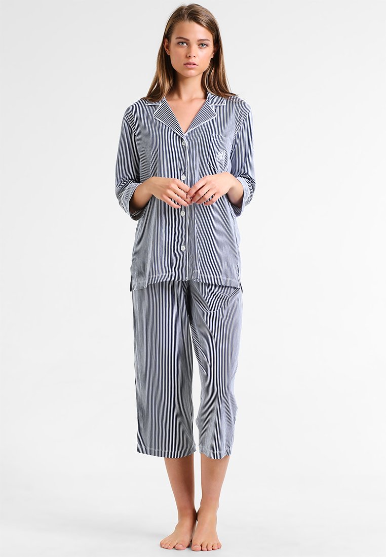 Raidoitu kaksiosainen pyjama-asuste tummansinisenä ja valkoisena. Napillinen paita pitkillä hihoilla ja lyhyet housut. Pehmeä kankaan rakenne.