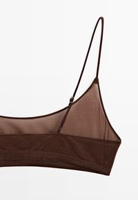 Brun bralette med tynde stropper, lavet af gennemsigtig og tekstureret stof. Har en glat bånd og minimalistisk design med justerbart hardware.