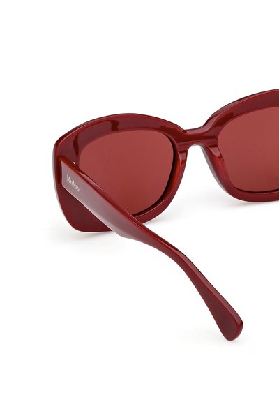 Gafas de sol rojas con acabado brillante, diseño angular y lentes tintadas. Las patillas son elegantes y alargadas con detalles de marca sutiles.
