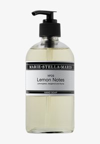 Heldere glazen fles met een zwarte pomp, gelabeld "Lemon Notes", met een zwart-wit ontwerp; bevat transparante vloeibare zeep.