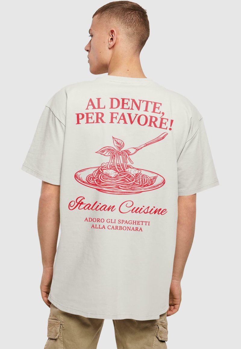 Hvid oversized t-shirt med rød tekst og spaghetti-grafik på ryggen. Teksten siger "AL DENTE, PER FAVORE! Italiensk køkken."