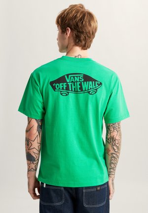 Grünes Baumwoll-T-Shirt mit schwarzem "Vans 'Off the Wall'"-Aufdruck auf der Rückseite, Rundhalsausschnitt, kurze Ärmel und lockere Passform.