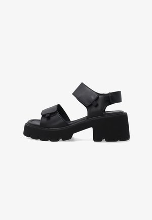 Sort chunky sandal med hæl med to justerbare velcrostropper, åben tå og tyk tekstureret sål, vist i sideprofil.