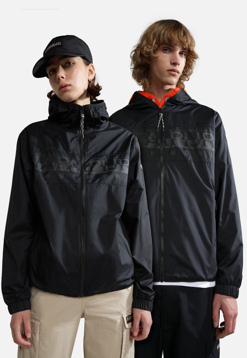Zwarte lichtgewicht jassen met ritsvoorkant en capuchons, met elastische manchetten. Eén jas heeft oranje accenten en logo-details.