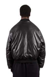 Black leather bomber jacket features a smooth texture, ribbed cuffs and hem, and a relaxed silhouette with a slightly glossy finish.