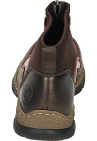 Bottine en cuir marron avec une finition lisse, dotée d'un col rembourré, d'une semelle texturée et d'une touche rouge contrastante. Fermeture éclair à l'arrière.