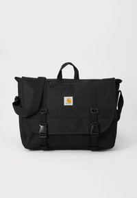 Sac messager noir en tissu durable, doté d'une fermeture à rabat, d'une bandoulière réglable et d'une patch logo à l'avant avec des accents en métal.