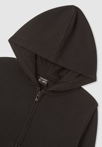 Felpa con cappuccio nera con cerniera, caratterizzata da un cappuccio, tessuto morbido e etichetta interna. La cerniera e le cuciture sono dello stesso nero.