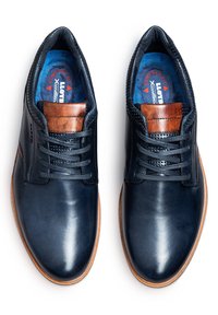 Marineblaue Lederschuhe mit glatter Oberfläche, braunen Lederakzenten, durchbrochener Detailgestaltung und blauen Einlegesohlen mit einem Komfortpasslabel.