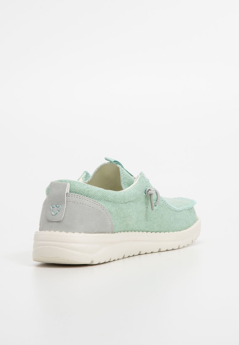 Scarpa in tela verde menta con tacco in suede grigio, forma arrotondata, tessuto texture, interno morbido e dettaglio a loop sul lato.
