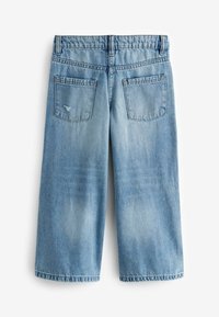 Ljusblå denimculotter med en avslappnad passform, som har två bakfickor och en fransad fåll. Tyget visar på liten blekning och texturvariationer.