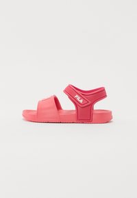 Sandale din cauciuc roz cu talpă plată, având o curea lată peste picior și o curea pentru călcâi, gravată cu logo-ul Fila.