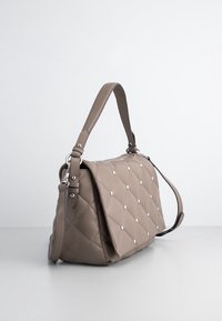 Quiltet beige læder skuldertaske med sølvnitter, en flad klap og en aftagelig skulderrem. Har et elegant design og en blød tekstur.