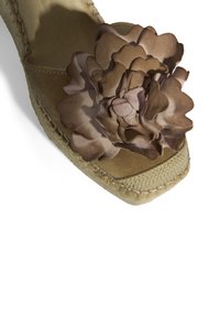 Beige Espadrilles mit Keilabsatz, ausgestattet mit einem glatten Stoffblütenakzent, runder Spitze und strukturiertem Jutesohle. Die Naht entlang des Randes verleiht dem Design zusätzlichen Charme.