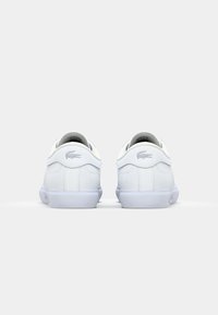 Białe skórzane trampki o gładkiej fakturze, zaokrąglonym kształcie i niskim fasonie. Posiadają subtelne logo na pięcie oraz białą gumową podeszwę.