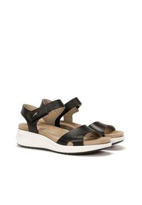 Sandalias de cuero negro con punta abierta y correas entrelazadas; plantilla acolchada; suela ligera blanca con suela exterior negra texturizada.