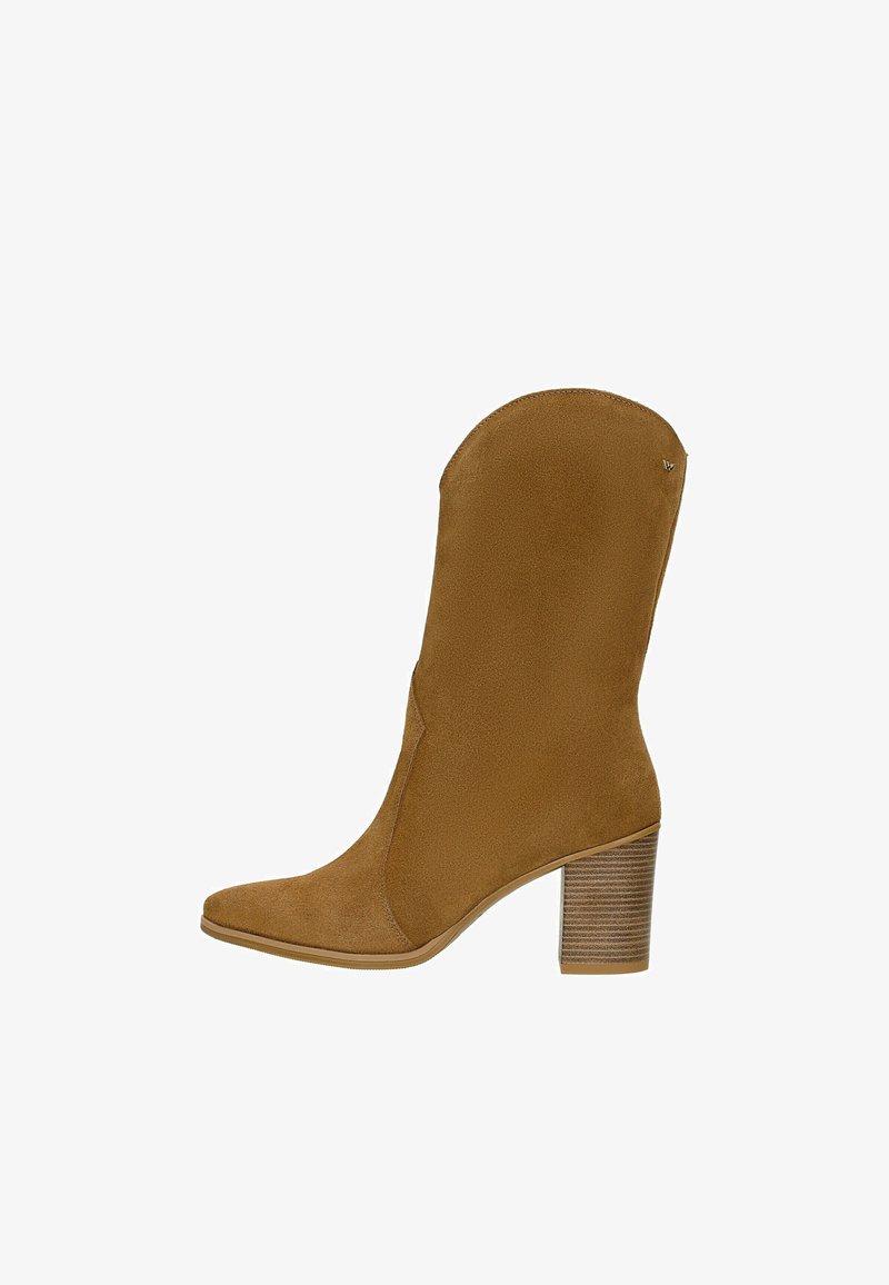Brązowy zamszowy botek do kostki z wydłużonym noskiem, gładką cholewką i paskowym obcasem. Posiada subtelny detal wzdłuż szwu bocznego.