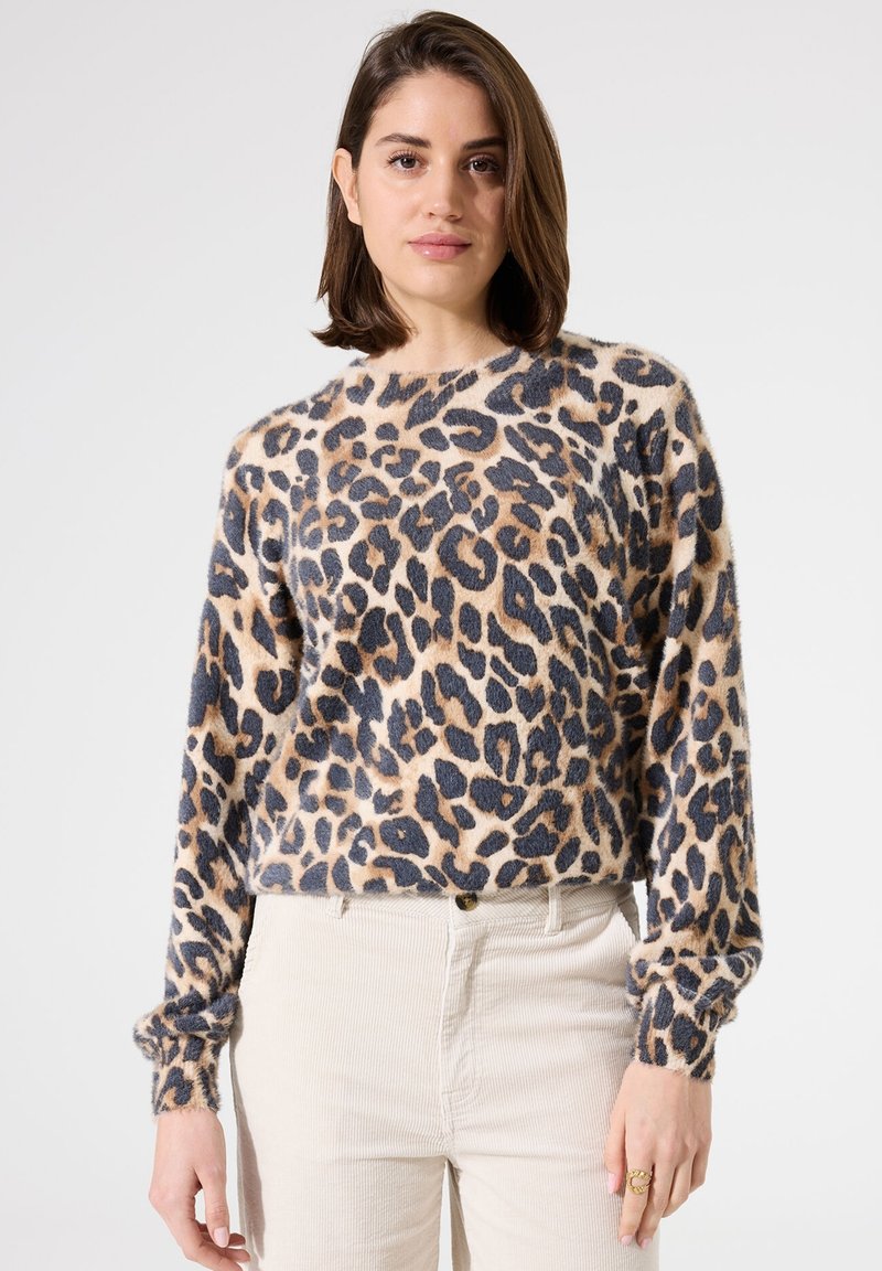 Pull en imprimé léopard en matériau doux, avec des manches longues, un col rond et une coupe décontractée. La palette de couleurs comprend du beige, du noir et du marron.