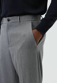 Grijze op maat gemaakte broek met een gestructureerde stof, voorzien van een vlakke voorkant, zijzakken en een enkele knoopsluiting bij de taille.