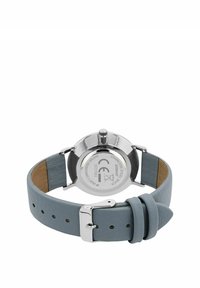 Runde Uhr aus Edelstahl mit einem hellblauen Lederarmband, ausgestattet mit silbernen Beschlägen und einer glatten, matten Textur des Armbands.