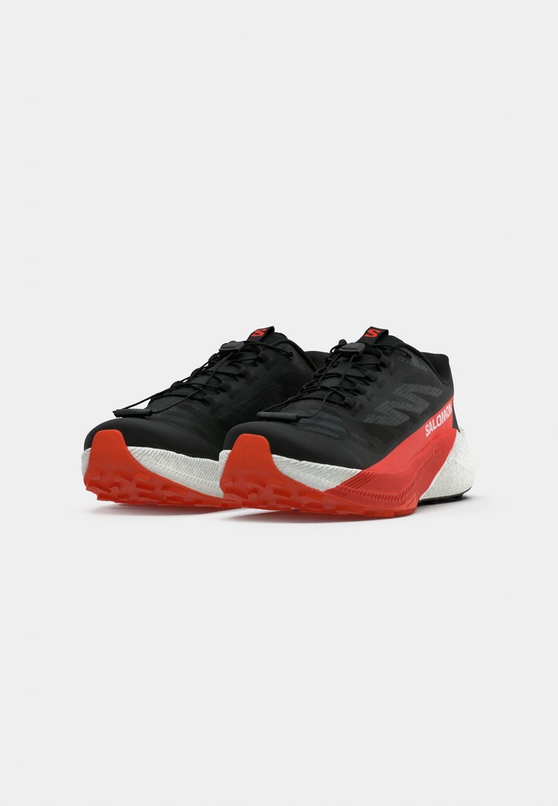 Schwarze Laufschuhe mit roten Akzenten, strukturiertem Obermaterial, gepolstertem weißen Zwischensohlenelement und gemustertem Gummilaufsohle. Leichtes Design für optimale Leistung.