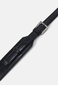 Ceinture en cuir synthétique noir à motif crocodile avec une boucle rectangulaire en argent brillant et une sangle réglable. Présentant des motifs texturés distincts et des coutures.