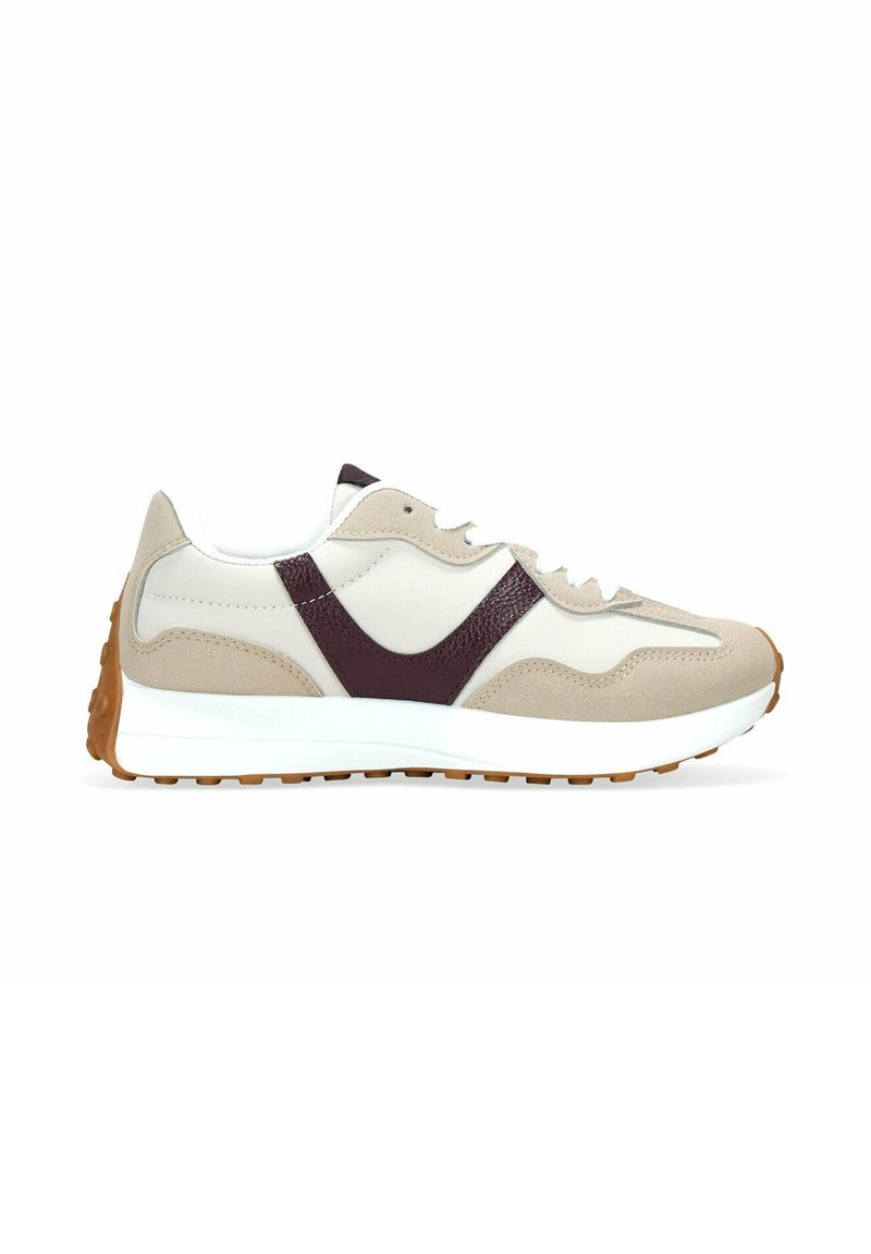 Zapatilla beige y blanca con acentos de cuero color marrón, suela blanca y suela de goma, mostrada de lado sobre un fondo blanco.
