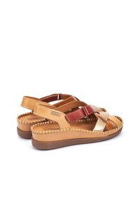 Sandalias de cuero marrón que presentan una combinación de acentos en rojo y dorado, con un detalle de costura a lo largo de los bordes y una suela plana.
