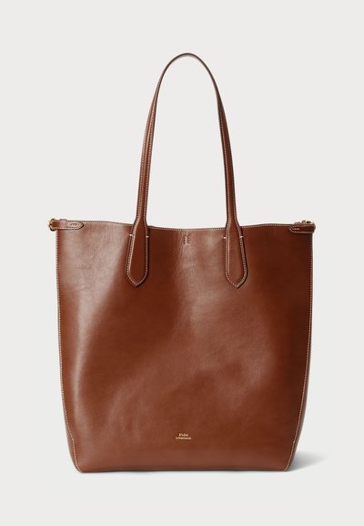 Bolso tote de cuero marrón con dos asas largas, textura suave y diseño minimalista. Incluye costuras sutiles y cierre de cremallera.