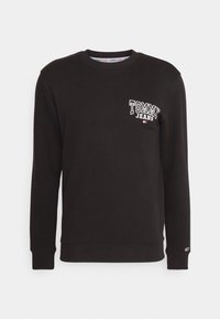 Felpa in cotone nera con colletto rotondo, polsini e vita a coste. Presenta il logo bianco "TOMMY JEANS" sul petto sinistro e un accento colorato.