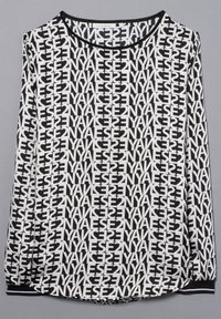 Vit långärmad topp med ett djärvt mönster i svart text. Rund halsringning med svart kant och ribbade ärmslut. Mjuk tyg, avslappnad passform.