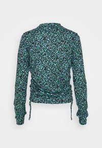 Långärmad blus med en samlad design. Svart tyg med gröna och blå leopardliknande mönster. Justerbara sidoknyt för passform.