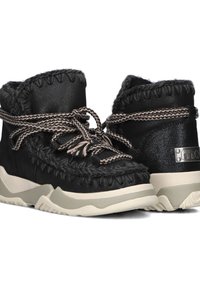 Bottines noires avec un dessus texturé, des lacets tressés et une semelle contrastante couleur crème. Présente des coutures décoratives et un accent de logo.