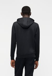 Sweatshirt preta com capuz, feita de tecido liso, com bolso canguru, punhos canelados e capuz com cordão. Vista traseira exibida.