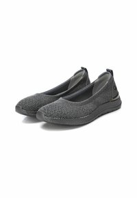 Un par de zapatos casuales de punto gris oscuro, tipo slip-on, con suelas de goma flexibles y lengüetas en los talones sobre un fondo blanco.