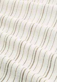 Textil med en vit bakgrund och fina, horisontella bruna ränder. Tyget verkar mjukt och något texturerat, vilket skapar subtila vågor.