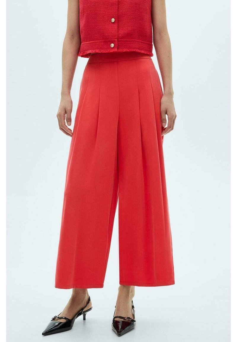 Pantalones anchos plisados rojos con una textura suave, cintura alta y una blusa corta a juego. Acabados con detalles de botones.