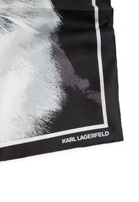 Silketørklæde med et sort-hvidt abstrakt design med kraftige stræk, indrammet af en tynd hvid kant og teksten "KARL LAGERFELD".