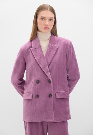 Double-breasted lilac corduroy blazer with notched lapels, two front pockets, and dark buttons, paired with a cream turtleneck underneath.