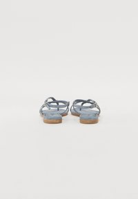 Sandales en suede bleu avec une semelle en bois plate, dotées de plusieurs sangles croisées et d'une boucle pour un maintien sécurisé à la cheville.