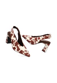 Zapatos de tacón con punta afilada y tiras traseras, hechos de una tela texturizada con un estampado de vaca en marrón y crema, que cuentan con un tacón bloque para mayor estabilidad.