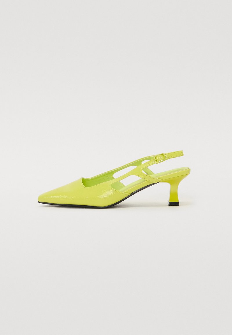 Chaussure slingback jaune avec un bout pointu, finition brillante, design avec des découpes sur les côtés et un petit talon épais.