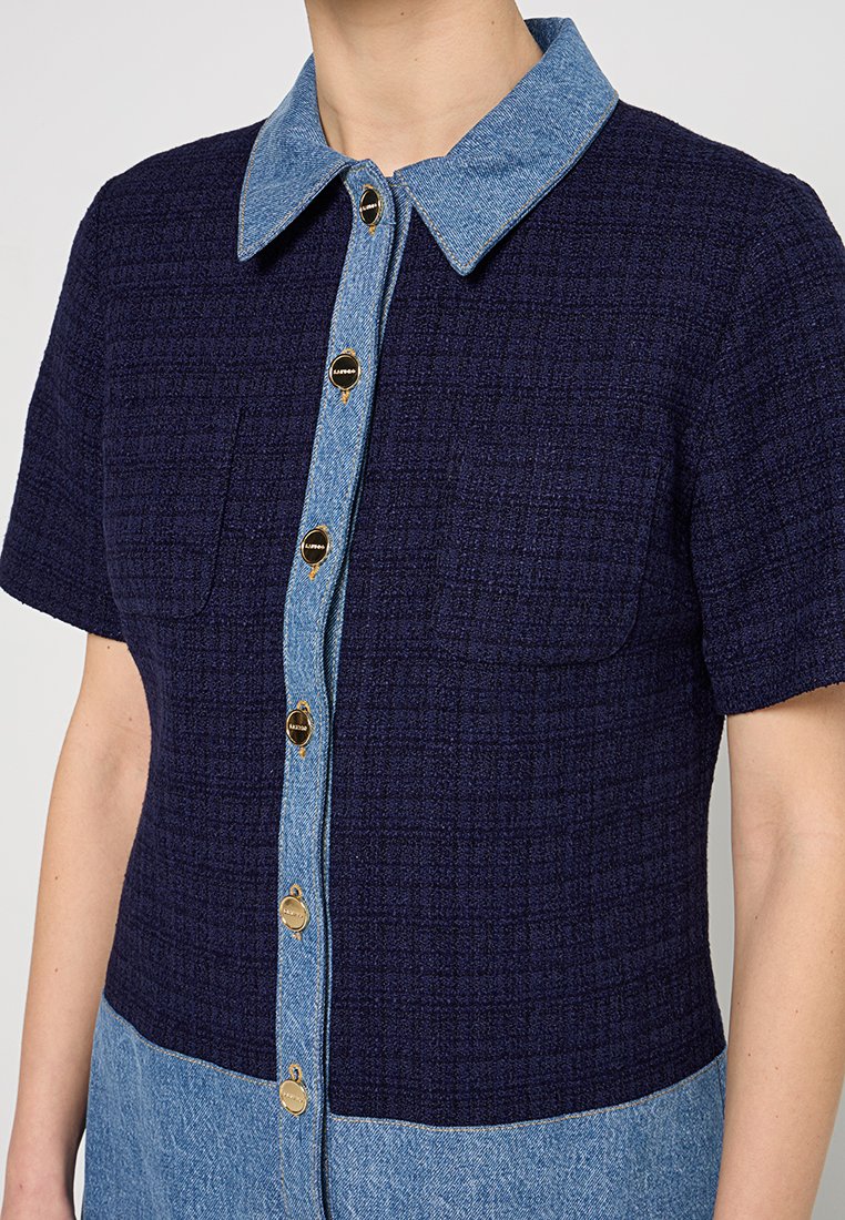 Navyblaues, strukturiertes Shirtkleid mit einem Denimkragen, das goldene Knöpfe auf der Vorderseite und zwei Brusttaschen hat.