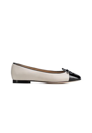 Ballerina da donna con tacco basso in pelle beige con punta nera lucida e piccolo fiocco sul davanti.