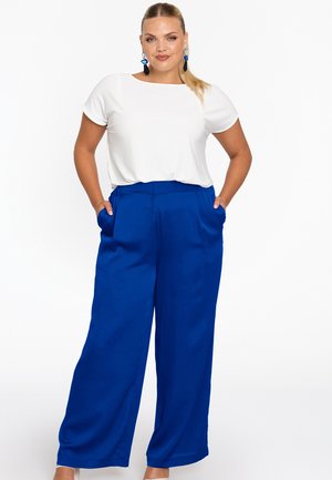 Witte top met korte mouwen, gecombineerd met wijde blauwe pantalons met zakken, een gladde textuur en een hoge taille.
