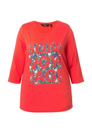 Maglia rossa a maniche lunghe con scollo rotondo e grafica a blocchi floreali con la scritta "BON VOYAGE" in caratteri grassetto.