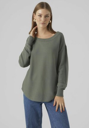 Khaki grøn løs pasform sweater med en bred udskæring og ribbede manchetter, parret med blå vide bukser. Blød strikstruktur og afslappet silhuet.
