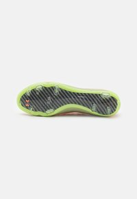 Suola di scarpa sportiva con un motivo in fibra di carbonio nera testurizzata, accenti in gomma verde e sei tacchetti trasparenti per la trazione.