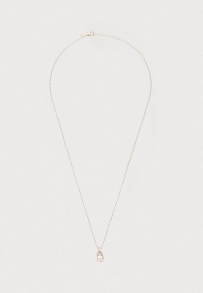 Stříbrný řetízek s malým oválným přívěskem z průhledného kamene na světlém jednobarevném pozadí.